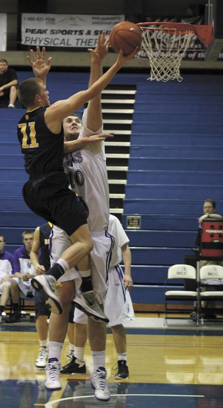 Lake Washington's Darien Nelson-Henry defends the basket as Bellevue's Jackson Rezab shoots during the KingCo title game on Thursday