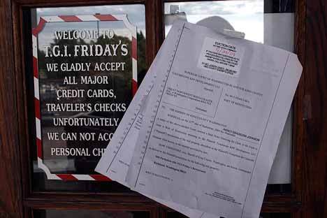 An eviction notice hangs on the doors of T.G.I. Friday’s at Park Place in downtown Kirkland after the company closed 10 restaurants on the West Coast.