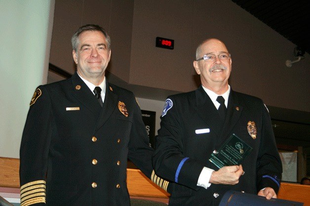 Kirkland Fire Chief J. Kevin Nalder (left) hands Ed Ulrich an award during a council meeting Tuesday