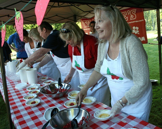 Kirkland Mayor Joan McBride scoops up some sweet strawberries during an annexation celebration on the north side of Juanita Beach Park on Friday.