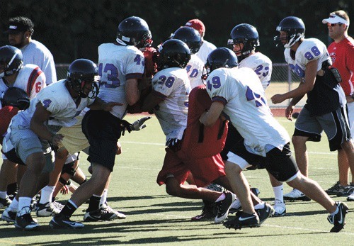 Members of the Juanita High School football team run through drills during a practice last week.