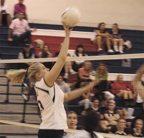 Juanita's Natalie Marrs tips the ball over the net during the Rebels first game against Mercer Island last week. The Rebels held on to win in five games