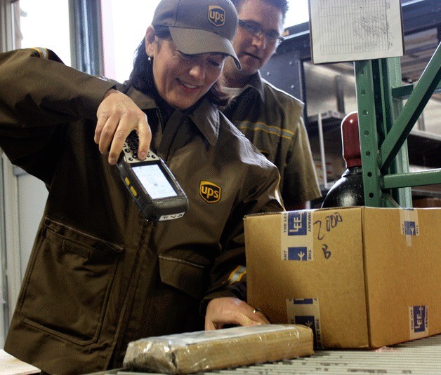 Congresswoman Suzan DelBene scans a package while UPS delivery driver Mike Vallimont watches on Wednesday morning at Triumph Aerospace Group on Redmond Ridge. DelBene