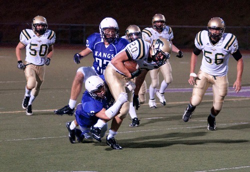 Lake Washington running back Alex Donnelly tackles Redmond tight end Conner Floan during Friday night’s 28-7 loss to the Mustangs.