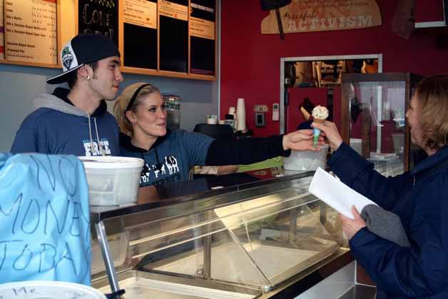 Sarah Conrad hands a cone to Nancy Pope as Marshall Kidder looks on during free cone day at Ben & Jerry's in Kirkland on Tuesday afternoon.