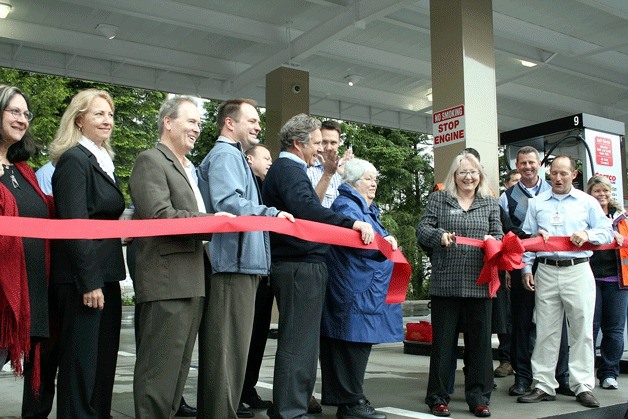 Kirkland Mayor Joan McBride cuts the ribbon to officially open the new Kirkland Costco gas station on Thursday morning as other city dignitaries and Costco officials look on.