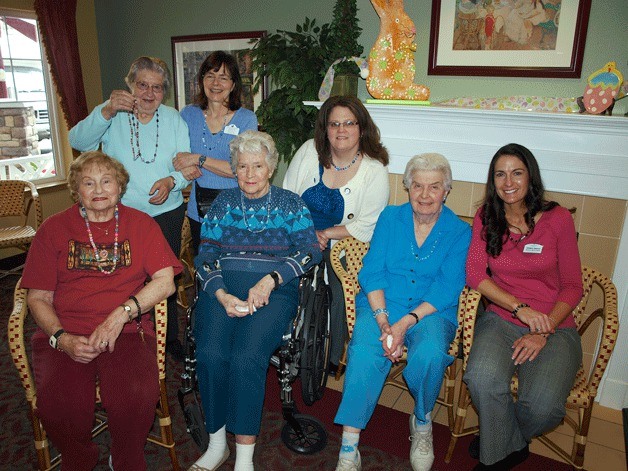 Friends and Emeritus staff gather around Gloria Matlock (second from right) to show off their beads she made for them.