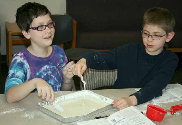 Siblings Eli (right) and Torrey Armstrong make a quicksand-like goop using cornstarch and water on Monday at the North Kirkland Community Center during the Gross Out Chemistry Camp.