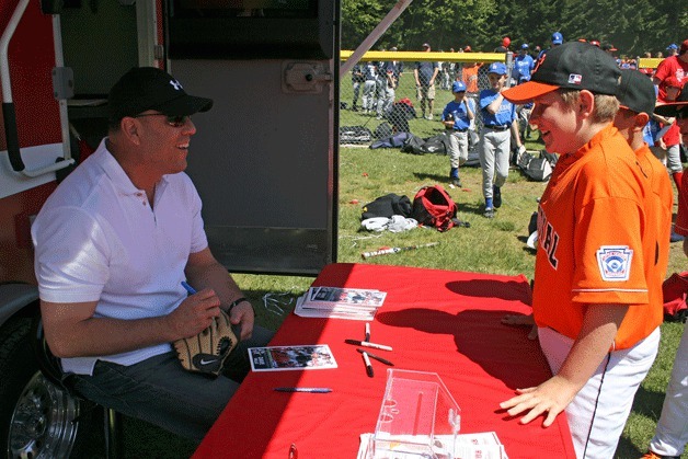 Former Seattle Mariner Dave Valle signs autographs during Kirkland National Little Leagues’ (KNLL) annual FanFest on Saturday at Big Finn Hill Park.