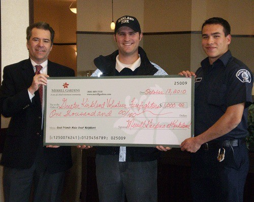 Merrill Gardens General Manager Stuart Ostfeld (left) presents a $1