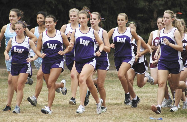 Members of the girls Lake Washington cross country team take off from the start line during the Kangs meet against Mercer Island and Interlake on Wednesday afternoon on Mercer Island.