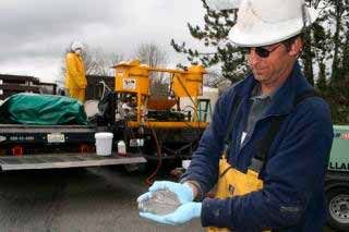 Sound Environment Strategies engineer Don Harden demonstrates the viscosity of the zero-valent iron slurry that was injected at the old Pace National Corporation site. They hope the substance will help decontaminate the soil of Vinyl Chloride.