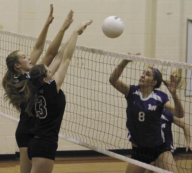 Lake Washington's Shelby Farrell (8) hits the ball over the net during the Kangs district loss to Mercer Island on Saturday