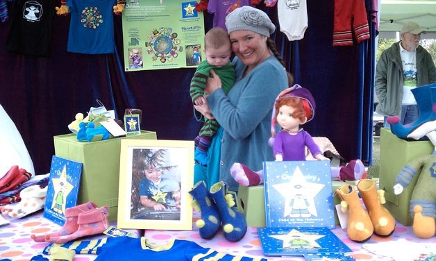 Children's author Schamet Horsfield holds her son during the 2011 Northwest Bookfest on Sunday at Peter Kirk Park. The event drew thousands of literary enthusiasts to several venues in downtown Kirkland over the weekend.