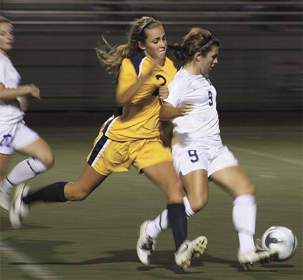 Lake Washington's Amy Johnson controls the ball as Bellevue's Emily Webb tries to steal it back during a Tuesday night conference game. The Wolverines won the game 4-1 over the Kangs.