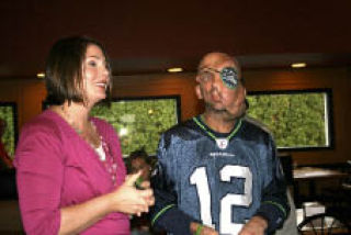 Katie Knopf of Bothell speaks with James O’Neal during a send-off party at the Pizza Bank in Kirkland Saturday. O’Neal will have surgery this week to get his facial tumors removed.