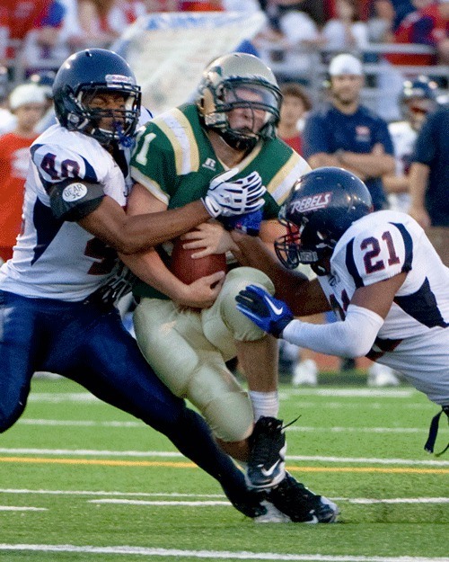 Juanita’s Charles Benjamin (left) and Suliasi Tamaivena (right) converge on Redmond running back Nico Shewey during Friday’s 41-7 victory. For the full story on this