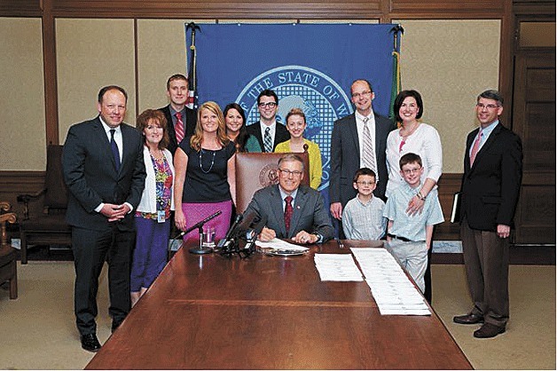 Gov. Jay Inslee signs Rep. Cyrus Habib's and Sen. David Frockt's children's health care bill into law on May 8.