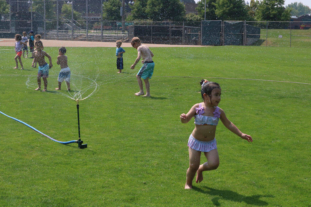 Back in 2017, local youngster cools off at the sprinkler park at Lee Johnson Field in downtown Kirkland. Now amidst the pandemic, the field is being used for another alternative: after-dark, socially distanced games and activities. File photo/ Samantha Pak